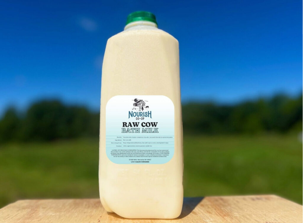 Nourish co-op raw cow "bath milk" on table on sunny day.